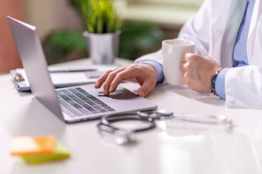 Close-up of doctor using laptop at his office. Healthcare concept.