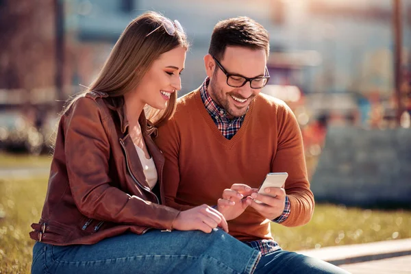 Mutlu genç çift dışarıda eğleniyor, selfie çekiyor.