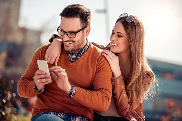 Mutlu genç çift dışarıda eğleniyor, selfie çekiyor.