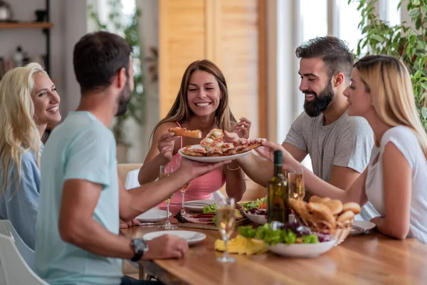 Group of friends have lunch together, eat and drink wine.