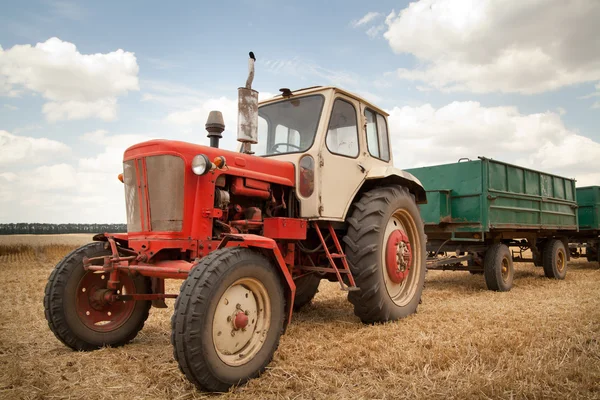Vieux tracteur dans le champ, contre un ciel nuageux — Photo