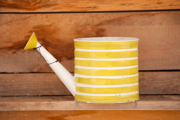 Old watering can on wooden background — Stock Photo, Image