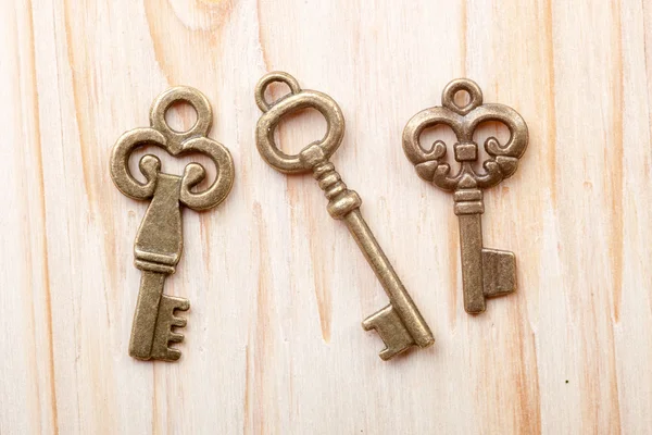 Ahşap zemin üzerinde üç vintage anahtar — Stok fotoğraf