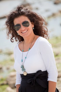 güneş gözlüklü genç gülümseyen kadın portresi.