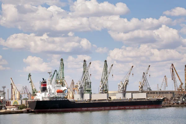 Large cargo ship in a dock at port. Cloudy sky — Stock Photo, Image