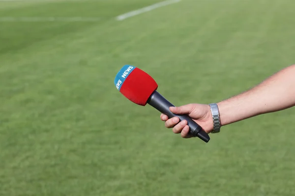 Hand met microfoon voor interview tijdens een voetbal mach — Stockfoto