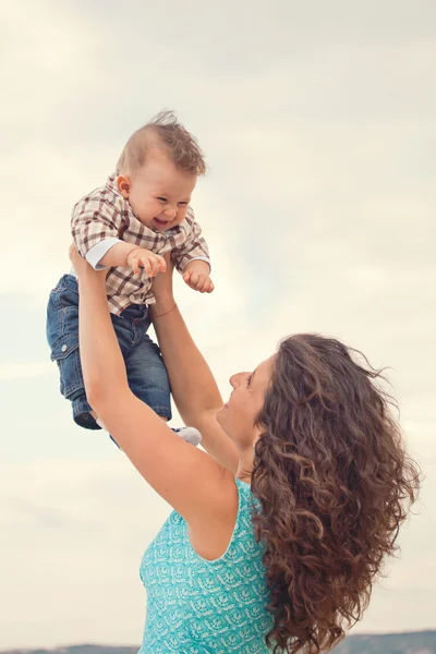 Mother playing with his baby. Rising baby up — Stock Photo, Image