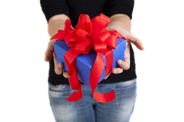 Голубая подарочная коробка с красной лентой в руках женщины — стоковое фото