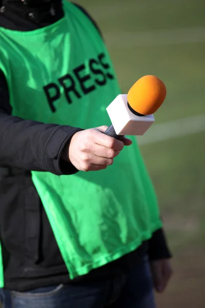 Elini tutmak mikrofon ile söyleşi sırasında futbol mach — Stok fotoğraf