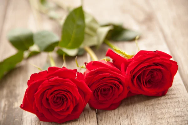 Rose rosse su sfondo di legno — Foto Stock