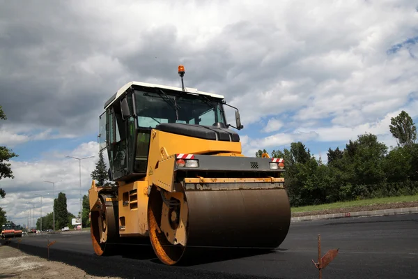 Grande rolo de estrada pavimentando uma estrada. Construção de estradas — Fotografia de Stock