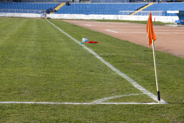 Drapeau d'angle sur un terrain de football avec des sièges vides — Photo