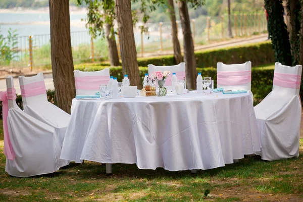 Стол, стулья и украшения на свадьбе, на открытом воздухе — стоковое фото