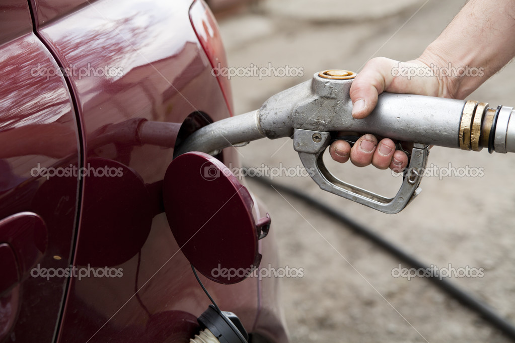 Nahaufnahme einer Hand, die mit einer Benzinpumpe Gas in das Auto