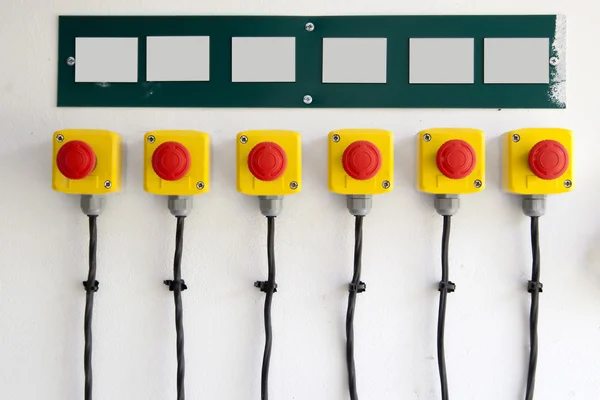 Червоні великі кнопки на стіні, з кабелями — стокове фото