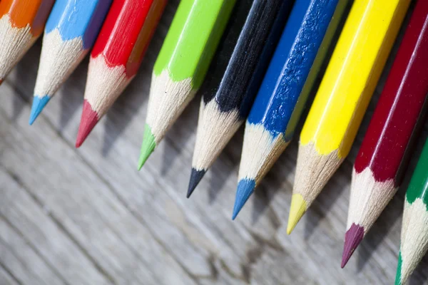 Bunch of color pencils over a wooden background — Stock Photo, Image