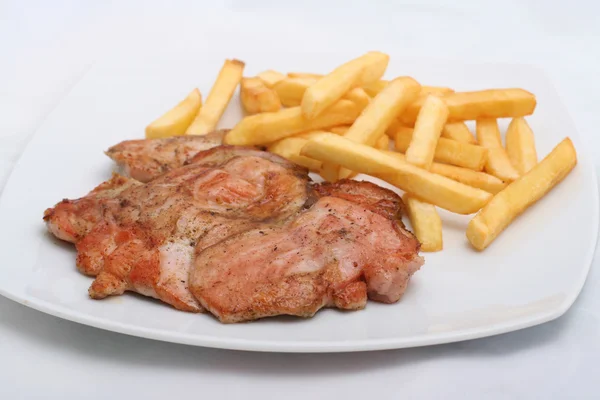 Juicy steak with french fries on a plate — Stock Fotó