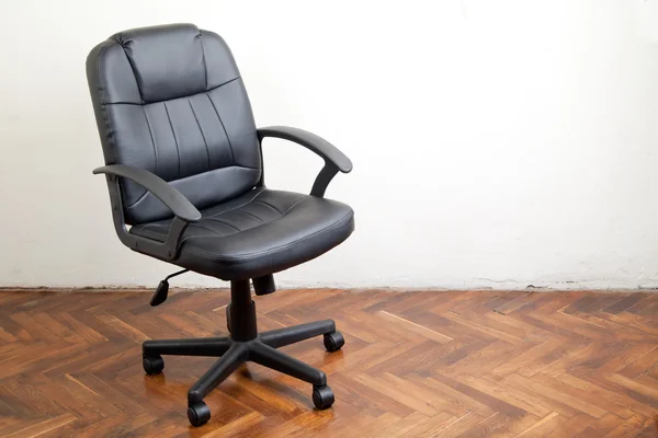 Czarne skórzane krzesło biurowe w pokoju — Zdjęcie stockowe