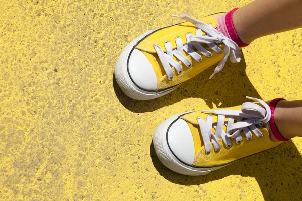 Scarpe da ginnastica gialle su sfondo giallo — Foto Stock