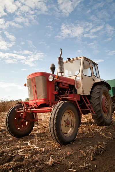 Gammal traktor i fält, mot en molnig himmel — Stockfoto
