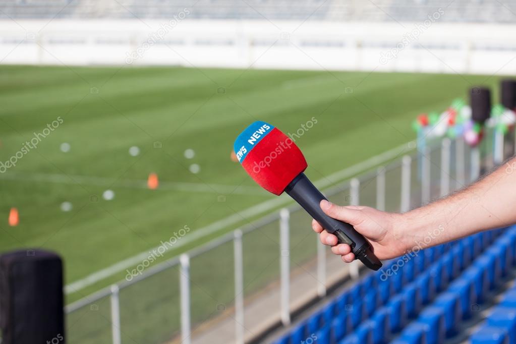 hand holding microphone for interview during a football mach