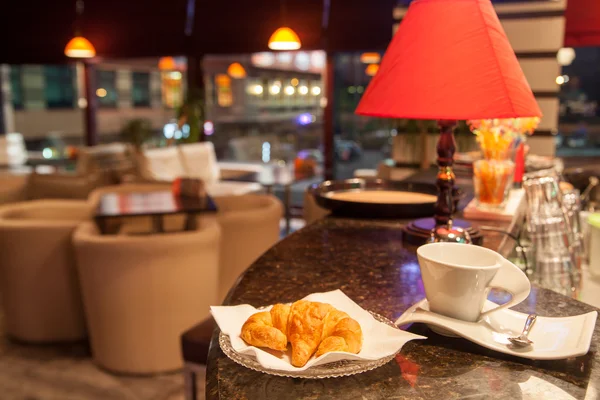 羊角面包和咖啡的杯状，在咖啡店 — 图库照片