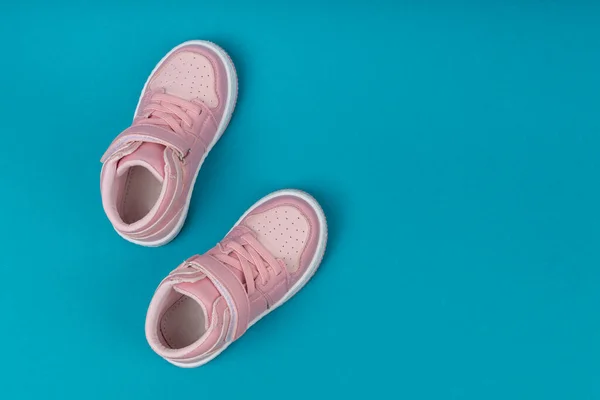 青の背景にピンクの子供の靴 女の子のための子供靴 — ストック写真