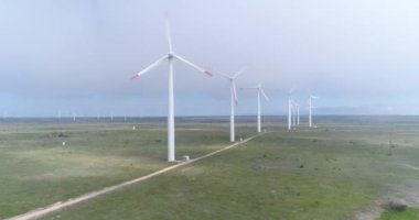 Bir rüzgar türbininin 4K hava aracı görüntüsü. Elektrik üretimi için yel değirmeni. Yeşil enerji. Yenilenebilir enerji.