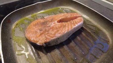 Kızartma tavasında somon balığı pişirmek. Sağlıklı yemek.