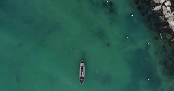 青绿色海洋中的孤零零的渔船和木制码头的自上而下的景象 — 图库视频影像