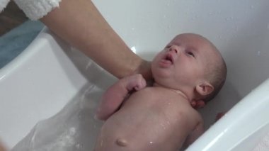 Anne yeni doğan bebeği için banyo yapıyor. Bebek banyosu zamanı