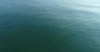 İnsansız hava aracı okyanus ve deniz üzerinde uçuyor. Suya yakın.