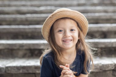 Şapkalı, gülümseyen tatlı küçük kız. 