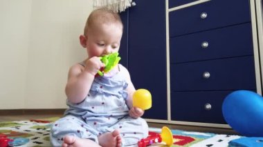 Küçük kız, evde yerde oyuncaklarla oynuyor.