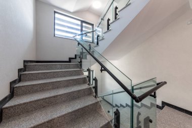 Katlar arasında modern merdiven. Modern binada metal raylı merdivenler