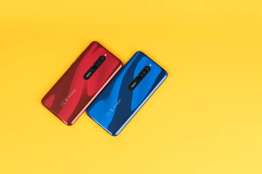 Varna, Bulgaristan - 16 Mayıs 2020: Kırmızı ve sarı arkaplanda Sapphire mavisi renkli Redmi 8 Android akıllı telefonlarının arkası. Redmi, Çinli elektronik şirketi Xiaomi 'ye ait bir markadır..