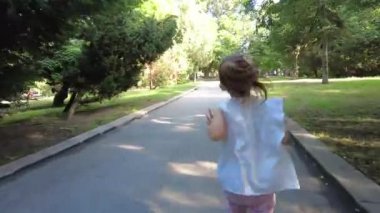 Parkta koşan küçük kız. Babasıyla kovalamaca oynuyor. Sıkıysa yakala beni. Baba ve kızı parkta birbirlerini kovalıyorlar.