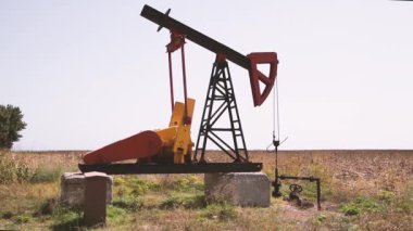 Fosil Yakıt Enerjisi. Endüstriyel yağ pompasının kapağı kırsal bölgede petrol pompalıyor.