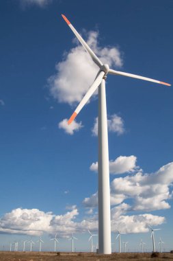 Mavi bulutlu gökyüzü üzerinde rüzgar türbini çiftliği