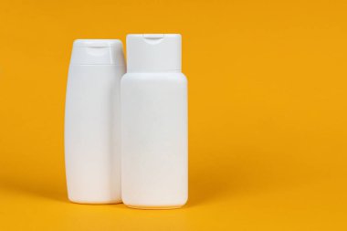 Sarı arka planda beyaz kozmetik kutuları. Cilt ürünleri seti. Yüz ve vücut bakımı kavramı.