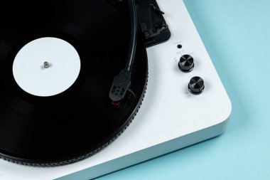 Mavi arka planda vinil plakalı vinil turntable. Modern gramofon kayıt cihazı. Müzik çalmak için geçmişe dönük ses teknolojisi