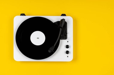 Sarı arka planda vinil plakalı vinil turntable. Modern gramofon kayıt cihazı. Müzik çalmak için geçmişe dönük ses teknolojisi