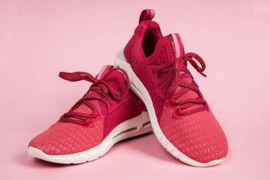 Bir çift yeni pembe spor ayakkabı, pembe arka planda spor ayakkabılar. Pembe kadın sporu, koşu ayakkabıları.