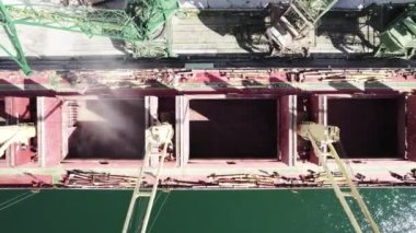  Limandaki vinçlerle kuru buğday kargo gemisi yükleniyor. Yukarıdan aşağıya doğru deniz kargo gemisinin ambarlarına yükleniyor
