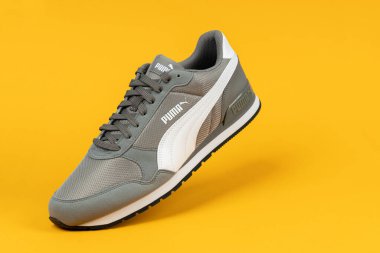 Varna, Bulgaristan - 18 Ağustos 2021. Sarı arka planda PUMA spor ayakkabısı. Puma, büyük bir Alman çokuluslu şirketi. Ürün çekimi