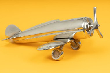 Metal model uçak oyuncağı, ön pervaneli. Sarı arkaplandaki Retro oyuncak