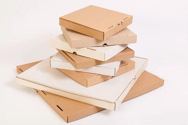 Different size and color pizza boxes. A tall stack of pizza boxes