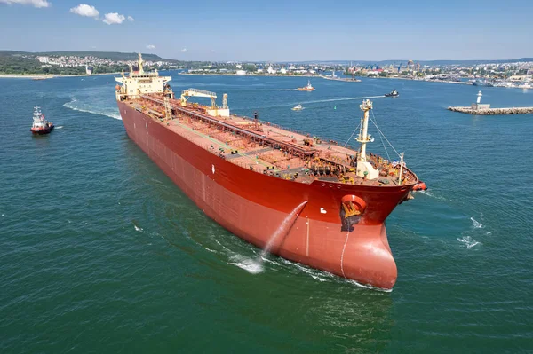 Aerial view of a red oil tanker leaves the port. Tanker ship logistic and transportation business oil and gas industry.
