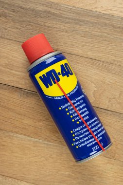 VARNA, BULGARIA - 19 Mayıs 2022: WD-40 ahşap arka planda. Çoklu kullanım ürünü metali paslanma ve aşınmadan korur