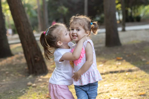 Two little girls sisters hugging. Happy funny girl sisters hugging and laughing
